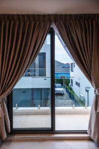 a window with curtains and a view of a building at Stylish 2-Bedroom Apartment at East Legon in Ajiringano