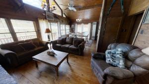 a living room with leather furniture and a table at Pet Friendly - WiFi - Washer - Dryer - Fireplace - Grill in Red River