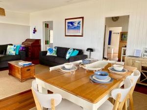 a living room with a wooden table and a dining room at Burrum Beach House-Waterfront-Private Jetty-2BR in Toogoom