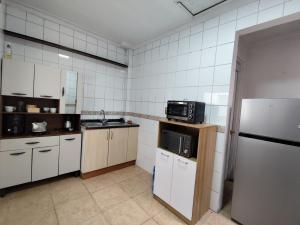 una cocina con nevera y microondas en Casa CasCal, en Santiago 17 fotos más