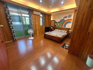 a bedroom with a bed and a rainbow painting on the wall at New Fox Guest House in Zhuangwei