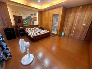 a bedroom with a bed and a fan in a room at New Fox Guest House in Zhuangwei