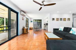 a living room with a couch and a ceiling fan at Beaches in Toogoom +14 photos