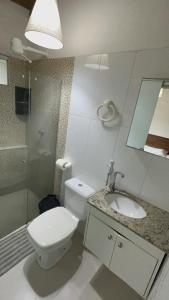 Un baño con inodoro, lavabo y ducha. en Recanto Mucugê, en Porto Seguro