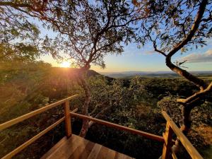 a view of the sunset from a wooden deck at Chalé Angico - Refúgio Namata in Pirenópolis
