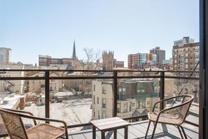 a balcony with two chairs and a view of a city at Modern East Side 1BR Apt with Balcony, Pool, and Gym in Milwaukee