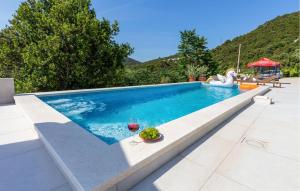 una piscina con una copa de vino y una copa de vino en Gorgeous Home In Ploce, en Ploče 38 fotos más