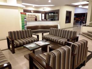 
a living room filled with couches and chairs at Hotel Panchavati Yatri in Nashik
