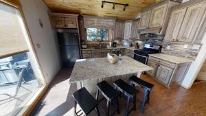 a large kitchen with a large island with bar stools at Caribel Trail Lodge - Hot Tub - Grill - Satellite - WiFi - Washer - Dryer - Garage Access in Red River