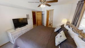 a bedroom with a large bed and a flat screen tv at Caribel Trail Lodge - Hot Tub - Grill - Satellite - WiFi - Washer - Dryer - Garage Access in Red River +39 photos