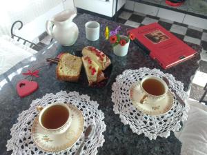 a table with two cups of tea and bread at Casas de Epoca -Limerencia in Charbonier