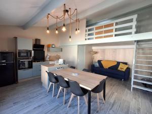 a kitchen and living room with a wooden table and chairs at Appartement cosy avec mezzanine, proche plage et commerces - Châtelaillon-Plage - FR-1-706-29 in Châtelaillon-Plage