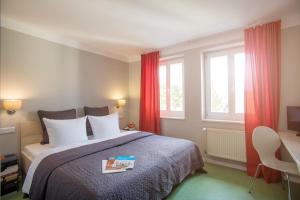 a bedroom with a bed with a book on it at Velo Inn Basislager Bad Berka in Bad Berka