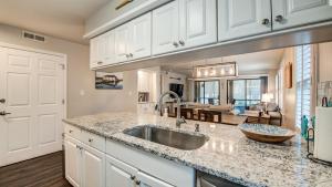 a kitchen with a sink and a living room at 142-2 A Peace of Pawleys condo by Peace Vacations in Pawleys Island