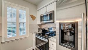 a kitchen with white cabinets and a stove top oven at 142-2 A Peace of Pawleys condo by Peace Vacations in Pawleys Island +13 photos