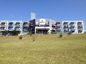 a large building with a field in front of it at Hotel Cedro Palace in São José do Cedro
