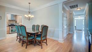 a dining room with a table and green chairs at Good Trouble villa by Peace Vacations in Georgetown +23 photos