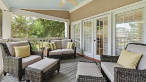 a screened in porch with chairs and a couch at Salty Sister Villa by Peace Vacations in Georgetown