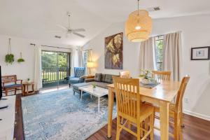 a dining room and living room with a table and chairs at 52F True Blue Golf Getaway condo by Peace Vacations in Pawleys Island