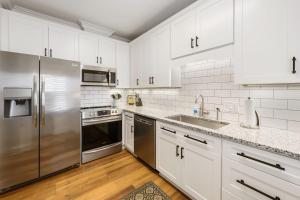 a kitchen with white cabinets and stainless steel appliances at Caddyshack home by Peace Vacations in Georgetown