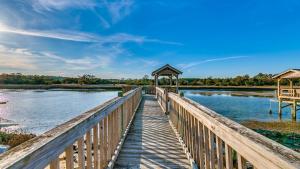a wooden bridge over a river with a gazebo at Magnolia in Pawleys Island home by Peace Vacations in Pawleys Island