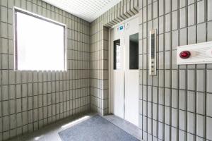 a hallway with a white door and a window at E-Horizon北2条ビル in Sapporo