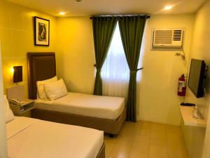 Postel nebo postele na pokoji v ubytování Cebu Uncle Tom's Cabin Hotel powered by Cocotel