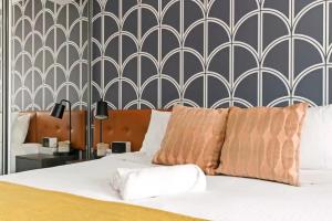 1 dormitorio con cama blanca y pared en KozyGuru | Haymarket | Chic City Studio, en Sídney