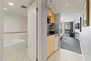 cocina con bañera y lavabo en una habitación en KozyGuru | Haymarket | Chic City Studio, en Sídney