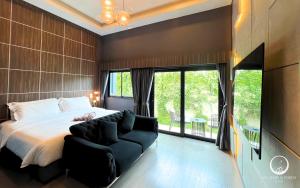 une chambre avec un grand lit et un canapé dans l'établissement See Stars & Forest Resort, à Amphoe Sawang Daen Din