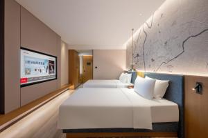 Postel nebo postele na pokoji v ubytování IntercityHotel Jingdezhen Taoxichuan