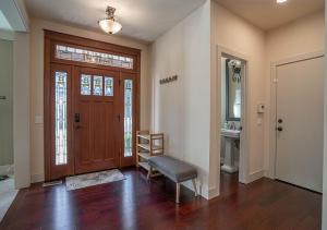 a living room with a wooden door and a chair at Kirkland's Expansive Custom-Built Family Haven Near Juanita in Kirkland
