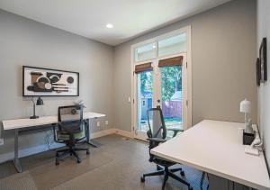 an office with two desks and chairs and a window at Kirkland's Expansive Custom-Built Family Haven Near Juanita in Kirkland