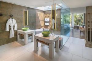 a bathroom with two sinks and a glass wall at W Bali - Seminyak in Seminyak