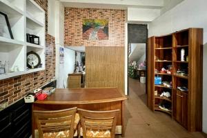 a kitchen with a bar with chairs and a brick wall at Backpacker Homestay Jatisampurna Redpartner in Bekasi