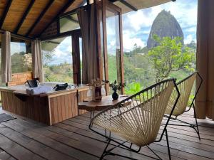 a room with a tub and chairs on a deck at Ecoedén glamping in Guatapé