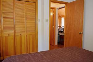 una camera con letto e armadio in legno di Deer Mountain Lodge - Hot Tub - WiFi - Washer - Dryer - Fireplace a Red River