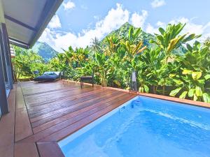 a house with a swimming pool and a wooden deck at Natura OM Teahupoo surf lodge in Toanoano