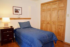 una camera da letto con un letto blu e un armadio di legno di Deer Mountain Lodge - Hot Tub - WiFi - Washer - Dryer - Fireplace a Red River Altre 88 foto