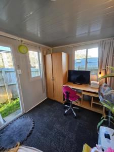 an office with a desk and a pink chair at C4 Save money budget affordable cabin with comfort! Cabin 4 in Auckland