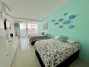 a bedroom with two beds and a blue wall at Marina del Sol 402 Vista al Mar in Mazatlán
