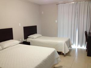 Cette chambre comprend 2 lits et une fenêtre. dans l'établissement Hotel Cedro Palace, à São José do Cedro