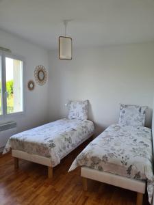 a bedroom with two beds and a window at Maison de vacances Angles in Angles