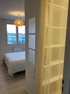 a bedroom with a bed and a glass closet at Appartement T3 classé 3 étoiles in Bayonne