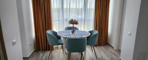 a table with chairs and a vase of flowers on it at Aphrodite Olimp - Luxury apartment with sea view & pool in Olimp