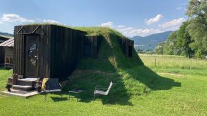un edificio con un tetto d'erba con due sedie e un tavolo di Domček v pieninach . a Majere