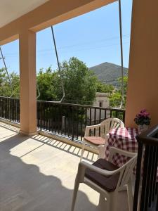 a balcony with two chairs and a table with a view at Γκαρσονιέρα δίπλα στη θάλασσα. in Kómi
