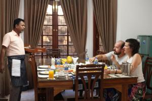 a group of people sitting around a dining room table at Kan̆du in Kandy