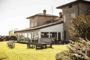 dom ze stołami i krzesłami na dziedzińcu w obiekcie Azienda Agrituristica Alcastlè w mieście Montabone