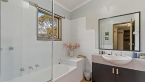 a bathroom with a sink and a tub and a mirror at Aaragon in Dinner Plain +9 photos